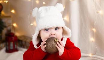 baby håller jul boll foto