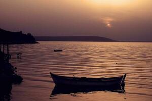 lugna landskap med en sjö och solnedgång och en båt foto