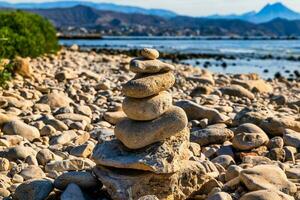 stenar staplade i torn på en sten strand foto
