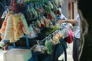 bogor, indonesien - 2022. en mobil vegetabiliska säljare med en vagn foto