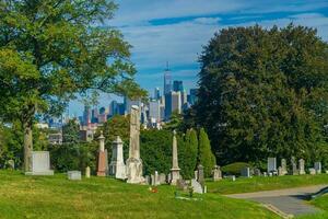 se av grön trä kyrkogård i brooklyn med manhattan stad horisont foto