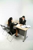 ung asiatisk manlig kvinna bär kostym Sammanträde på kontor skrivbord tänkande möte diskutera tecken dokumentera avtal hand skaka foto
