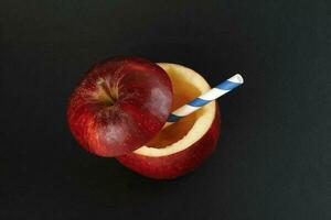 hälsa röd skära äpple återvinningsbar papper sugrör juice dryck aning begrepp på svart bakgrund foto