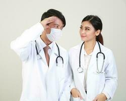 ung asiatisk manlig kvinna läkare bär förkläde enhetlig tunika förkläde håll foto