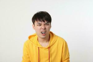 ung Bra ser asiatisk kinesisk malaysiska man utgör ansikte kropp uttryck läge känsla på vit bakgrund chockade överraskad äcklad foto