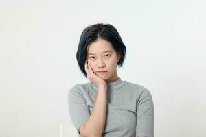 ung attraktiv asiatisk kinesisk malaysiska kvinna utgör ansikte kropp uttryck läge känsla på vit bakgrund hand på kind tänkande foto