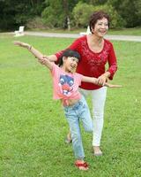 sydöst asiatisk multigeneration familj föräldrar dotter mormor far mor barn utgör Lycklig sitta stå foto