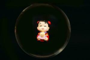 kinesisk docka genom glas spjut foto