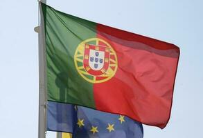portugisiska nationell flagga och flagga av de europeisk union vinka i de vind foto