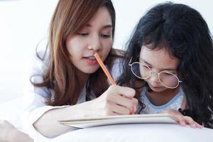 asiatisk mamma lär sin dotter läxor hemma foto