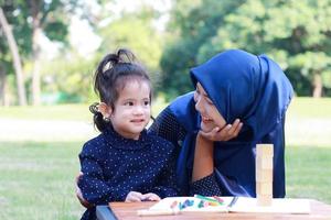 muslimsk mor och dotter njuter av sin semester i parken foto