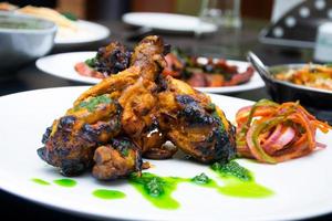 begreppet indisk mat kycklingben med kryddor och skor foto