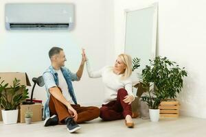 luft konditionering i levande rum med Lycklig familj rör på sig till ny lägenhet foto
