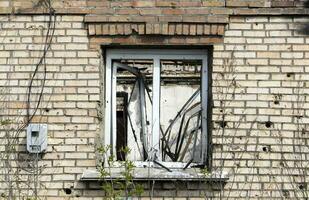 förstörd och skadad fönster i de byggnad som en resultat av de krig. de hus var förstörd och bränt förbi artilleri under de krig. bruten fönster. en fönster förstörd förbi de stridande. foto