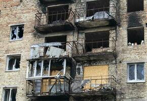 konsekvenser av de krig i de huvudstad av ukraina. en utbombade byggnad skadad förbi skal efter ett flyganfall. de raket blåste upp de hus. hål i de väggar från skal. foto