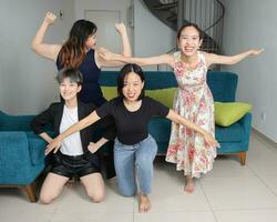 ung sydöst asiatisk kvinna grupp dans njuter roligt fest i levande rum foto