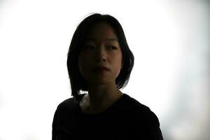 silhuett mörk svart porträtt av ung sydöst asiatisk kvinna på vit bakgrund roman kärlek vård vänner känsla uttryck tankar foto