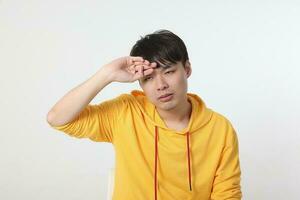 ung Bra ser asiatisk kinesisk malaysiska man utgör ansikte kropp uttryck läge känsla på vit bakgrund förlorat ledsen feber sjuk hand på huvud foto