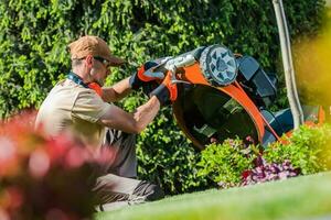 professionell trädgårdsmästare kontroll hans gräsmatta gräsklippare foto