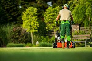 landskapsarkitekt tryckande scarifier maskin tar vård av de gräsmatta foto