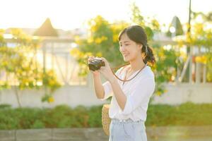 porträtt av asiatisk kvinna resande använder sig av kamera på gata av Bangkok, thailand. Asien sommar turism semester begrepp foto