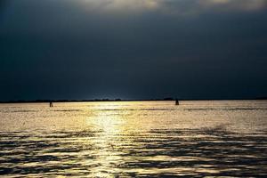 solnedgång över Venedigs lagun, Italien med gyllene reflektioner över havet foto