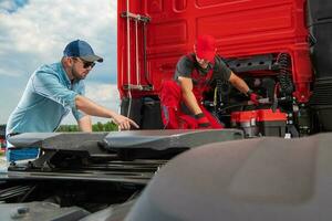 trucker som visar mekaniker en problem med hans lastbil foto