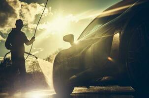 förare kraft tvättning hans prestanda bil under solnedgång foto