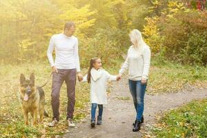 familj, sällskapsdjur, inhemsk djur- och människor begrepp - stänga upp av familj med tysk herde på promenad i parkera foto