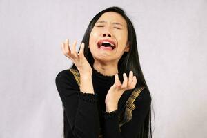 ung attraktiv sydöst asiatisk kvinna Framställ ansiktsbehandling uttryck gråta upprörd skrika foto
