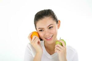 skön ung söder öst asiatisk kinesisk kvinna innehav friska grön äpple orange på vit bakgrund foto