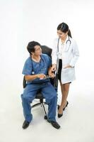 ung asiatisk manlig kvinna läkare bär förkläde enhetlig stetoskop sitta på stol stå prata diskutera foto