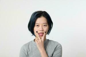 ung attraktiv asiatisk kinesisk malaysiska kvinna utgör ansikte kropp uttryck läge känsla på vit bakgrund trött tunga ut v finger foto
