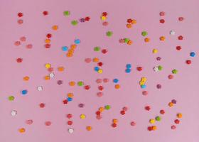färgglada söta konfettiblommor på rosa bakgrund foto
