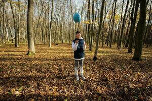 höst utomhus- porträtt av tonåring pojke med volleyboll boll i skog. foto
