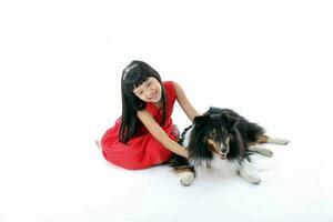 sydöst asiatisk ung flicka barn med sällskapsdjur hund spelar petting Lycklig foto