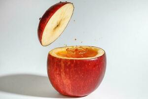 röd äpple verklig juice stänk i färsk halv skära ihålig kopp frukt foto