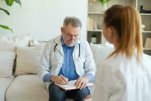 senior man läkare granskning yound kvinna i läkare kontor eller på Hem. flicka patient och läkare ha samråd i sjukhus rum. medicin sjukvård medicinsk kolla upp. besök till läkare. foto