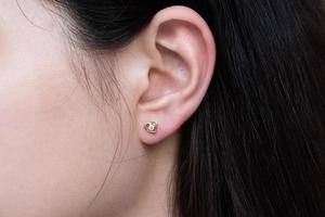 diamantörhänge på örat på en asiatisk kvinna foto