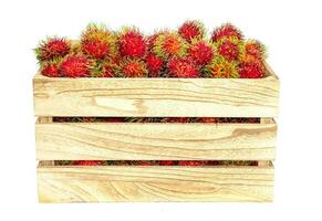 rambutan frukt i trä- crateon vit bakgrund foto