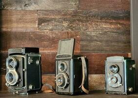 gammal antik kamera de samling är placerad på en trä- hylla. foto