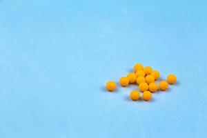 orange vitaminpiller på en blå bakgrund foto