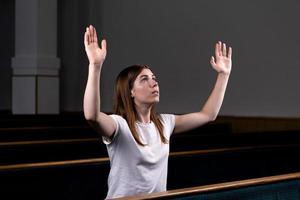 en kristen tjej som ber med ödmjukt hjärta i kyrkan foto