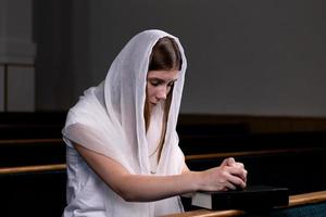 en kristen tjej som ber med ödmjukt hjärta i kyrkan