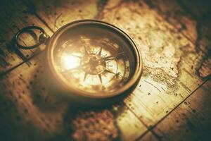 antik kompass liggande på papper värld Karta foto