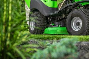 bakgård gräs klippning använder sig av ridning trädgård traktor foto