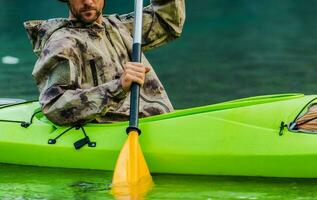 kayaker paddling på turkos sjö vatten stänga upp foto