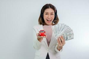 asiatisk kvinna innehav pengar och leksak bil foto