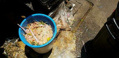 många mat avfall i de blå korg på de gata. smutsig plats och ohygienisk begrepp foto