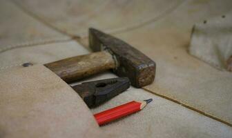 samling av träbearbetning gamla handverktyg i läderförkläde på en grov träbänk foto